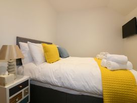 A bedroom with a bed and towels on the side at Fishermans Loft in Mevagissey