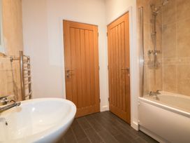 A bathroom with a bath tub and wash basin at Fishermans Loft in Mevagissey