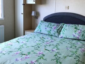 A bedroom with a bed and pillows at Beautifully Presented 2 Bedroom Static Caravan in Monreith near Whithorn