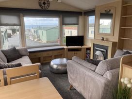 A living room with a sofa and television at Beautifully Presented 2 Bedroom Static Caravan in Monreith near Whithorn