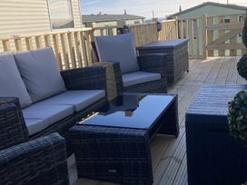 Outdoor patio with seating and a table at Beautifully Presented 2 Bedroom Static Caravan Monreith near Whithorn