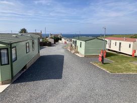 A view of caravans and pathway near the sea at Beautifully Presented 2 Bedroom Static Caravan in Monreith near Whithorn