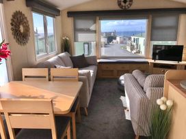 A living room with a sofa and dining table at Beautifully Presented 2 Bedroom Static Caravan in Monreith near Whithorn