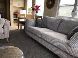 A living room with a sofa and dining table at Beautifully Presented 2 Bedroom Static Caravan in Monreith near Whithorn