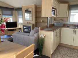 A living room with a sofa and television at Beautifully Presented 2 Bedroom Static Caravan in Monreith near Whithorn