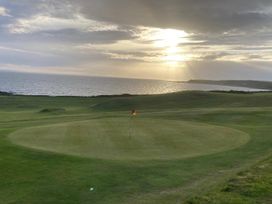 A golf course with a putting green and flag by the sea at Beautifully Presented 2 Bedroom Static Caravan in Monreith near Whithorn