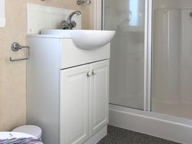 A bathroom with a sink and shower enclosure at Beautifully Presented 2 Bedroom Static Caravan in Monreith near Whithorn