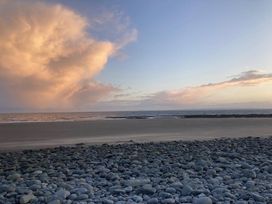 A beach with rocks and ocean at Beautifully Presented 2 Bedroom Static Caravan in Monreith near Whithorn