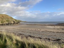 A beach with cliffs and ocean at Beautifully Presented 2 Bedroom Static Caravan Monreith near Whithorn