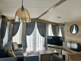 A living room with a sofa and television at The Old Barn in Manchester
