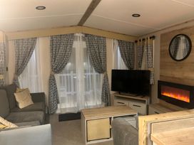 A living room with a sofa, TV, and electric fireplace at the property in 