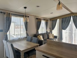 A living room with a table and chairs next to a sofa