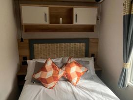 A bedroom with a bed and decorative pillows at The Old Barn in Manchester