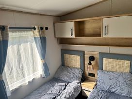 A bedroom with two beds and a shelf at a property