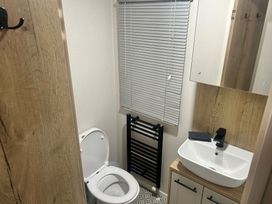 A bathroom with a toilet, sink, and mirror in a compact space