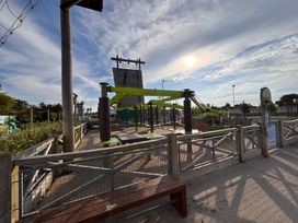 An outdoor obstacle course with climbing wall and benches at a recreational park