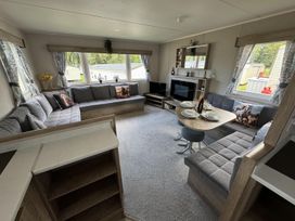 A living room with a sofa, coffee table, and television at West Lawn 47 Haggerston Castle Paddock Views, Haggerston