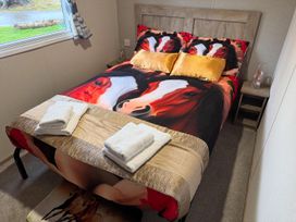 A bedroom with a double bed and horse-themed bedding at West Lawn 47 Haggerston Castle Paddock Views Haggerston
