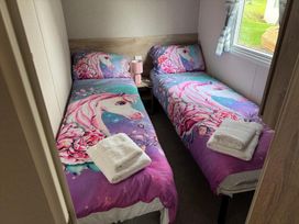 A bedroom with two single beds and a nightstand at West Lawn 47 Haggerston Castle Paddock Views Haggerston