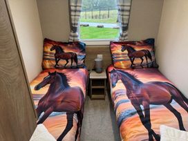 A bedroom with two beds and a window at West Lawn 47 Haggerston Castle Paddock Views Haggerston