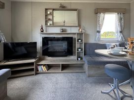 A living room with a sofa and television at West Lawn 47 Haggerston Castle Paddock Views Haggerston