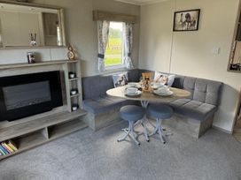 A living room with a sofa and dining table at West Lawn 47 Haggerston Castle Paddock Views Haggerston