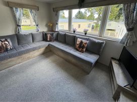 A living room with a corner sofa and television at West Lawn 47 Haggerston Castle Paddock Views Haggerston