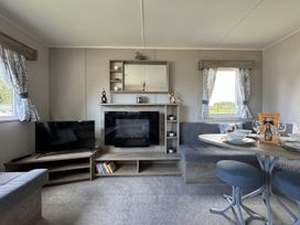A living room with a sofa and television at West Lawn 47 Haggerston Castle Paddock Views Haggerston