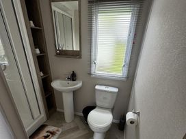 A bathroom with a shower, toilet, and sink at West Lawn 47 Haggerston Castle Paddock Views Haggerston