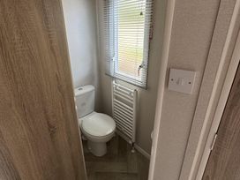 A bathroom with a toilet and radiator at West Lawn 47 Haggerston Castle Paddock Views Haggerston
