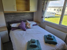 A bedroom with a double bed and towels at 3 Bed-Sleeps 8-Free Parking-5 Min to Beach Embo near Dornoch