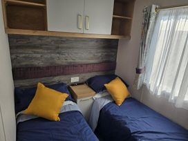 A bedroom with two beds and a wardrobe at 3 Bed-Sleeps 8-Free Parking-5 Min to Beach Embo near Dornoch