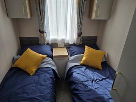 A bedroom with two beds and a side table at 3 Bed-Sleeps 8-Free Parking-5 Min to Beach, Embo near Dornoch