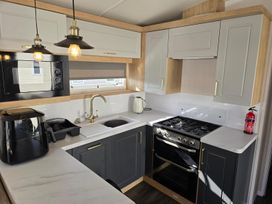 A kitchen with appliances and cabinetry at 3 Bed-Sleeps 8-Free Parking-5 Min to Beach in Embo near Dornoch