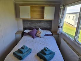A bedroom with a bed and towels at 3 Bed-Sleeps 8-Free Parking-5 Min to Beach Embo near Dornoch