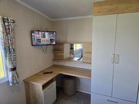 A bedroom with a desk and television at 3 Bed-Sleeps 8-Free Parking-5 Min to Beach in Embo near Dornoch