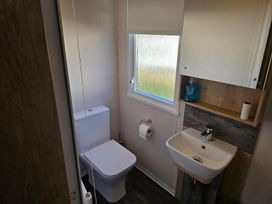 A bathroom with a toilet and sink at 3 Bed-Sleeps 8-Free Parking-5 Min to Beach Embo near Dornoch