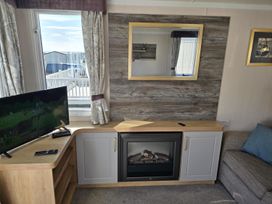 A living room with a television and a fireplace at 3 Bed-Sleeps 8-Free Parking-5 Min to Beach Embo near Dornoch