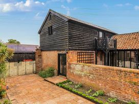 An outdoor area with a door, window, and plants at Barn Conversion Sleeps 2 with Parking in Diss