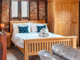 A bedroom with a bed, bedside table, and wardrobe at Barn Conversion Sleeps 2 with Parking in Diss