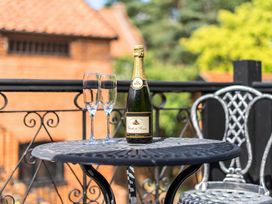Outdoor area with a table, champagne bottle and glasses at Barn Conversion Sleeps 2 with Parking, Diss