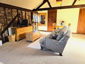A living room with a sofa and TV at Barn Conversion Sleeps 2 with Parking, Diss