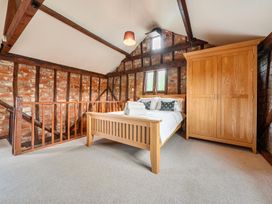 A bedroom with a bed and wardrobe at Barn Conversion Sleeps 2 with Parking in Diss