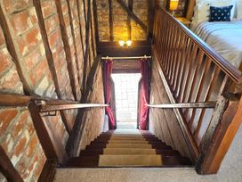 A staircase with wooden railings leading to a doorway at Barn Conversion Sleeps 2 with Parking in Diss