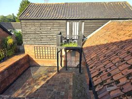 An outdoor area with a balcony and a paved ground at Barn Conversion Sleeps 2 with Parking in Diss