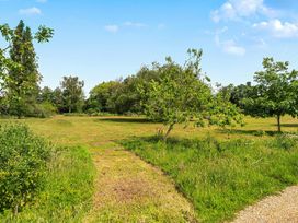 A grassy area with trees and a path at Barn Conversion Sleeps 2 with Parking in Diss