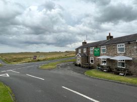 The exterior of Milecastle Inn on Hadrian's Wall near Haltwhistle with a road and signs