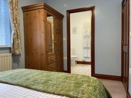 A bedroom with a wardrobe and door leading to a bathroom at Milecastle Inn on Hadrian's Wall near Haltwhistle