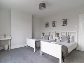A bedroom with two beds and bedside tables at East House-Sleeps 5-Pet friendly-Garden-Parking in Stakeford