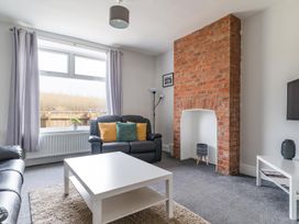 A living room with a brick fireplace and sofa at East House-Sleeps 5-Pet friendly-Garden-Parking in Stakeford